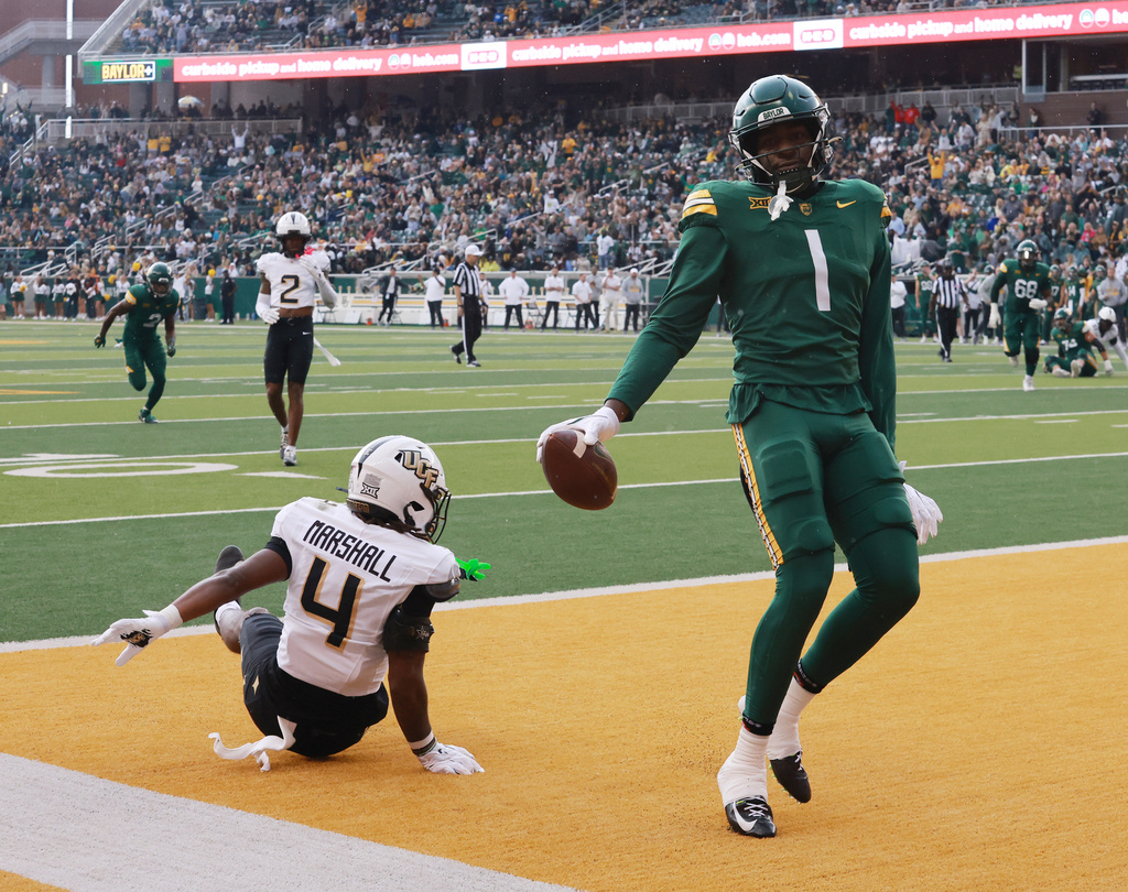 Baylor tight end Michael Trigg scores on a pass play over defensive back Braeden Marshall during the first half of an NCAA college football game, Saturday, Nov. 1, 2025, in Waco, Texas. (Rod Aydelotte/Waco Tribune-Herald via AP)