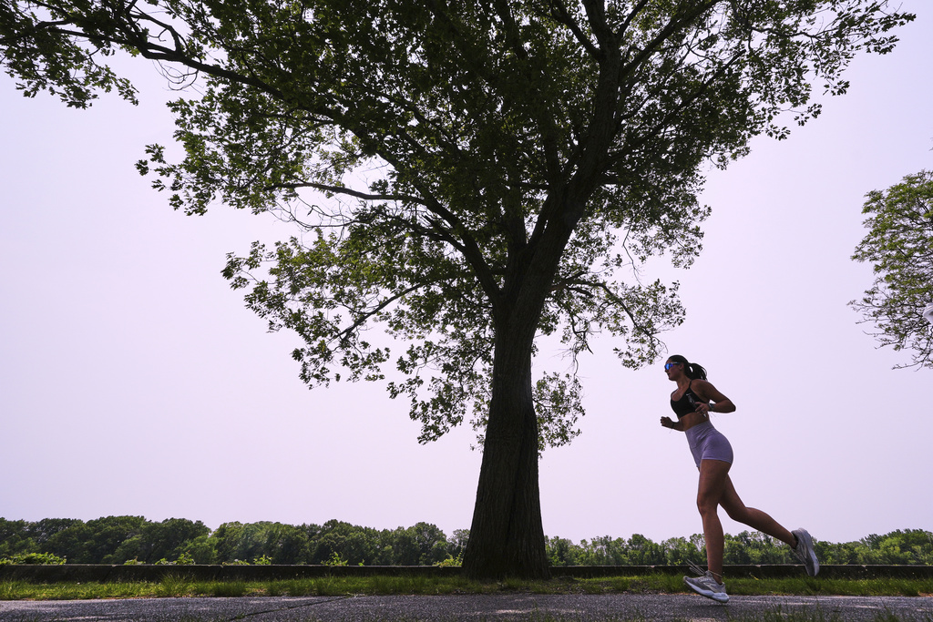 A woman runs along the banks of the Merrimack River, Wednesday, June 4, 2025, in Lowell, Mass. (AP Photo/Charles Krupa)