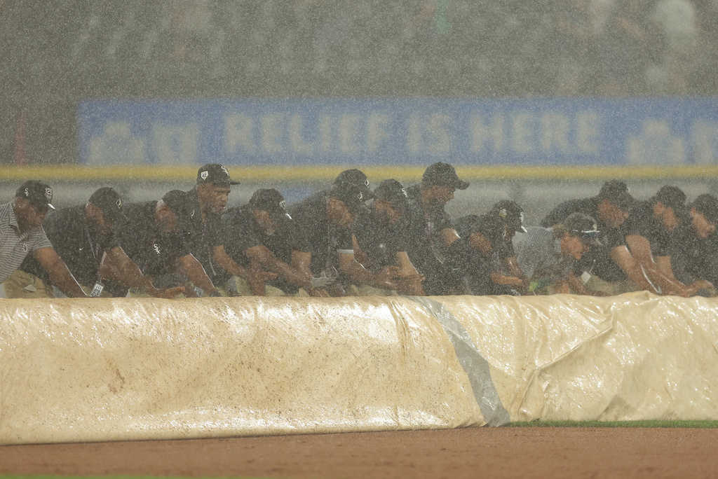 The Chicago White Sox grounds crew rolls out a tarp on the field as rain falls during the ninth inning of a baseball game against the Detroit Tigers, Monday, Aug. 11, 2025, in Chicago. (AP Photo/Melissa Tamez)