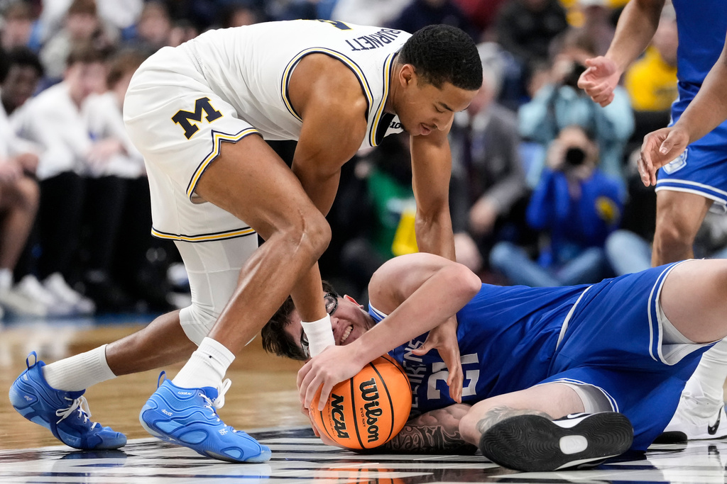 Saint Louis center Robbie Avila (21) fights for control of the ball with Michigan guard Nimari Burnett (4) during the first half in the second round of the NCAA college basketball tournament, Saturday, March 21, 2026, in Buffalo, N.Y. (AP Photo/Yuki Iwamura)