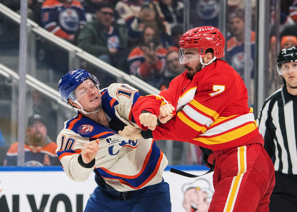 Calgary Flames' Kevin Bahl (7) fights Edmonton Oilers' Trent Frederic (10) during second period NHL action in Edmonton, Alberta, Tuesday, Dec. 23, 2025. (Amber Bracken/The Canadian Press via AP)