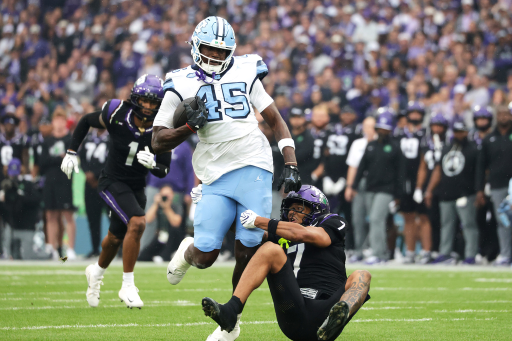 TCU safety Julius Simms, right, tackles North Carolina tight end Jelani Thurman during an NCAA college football game in Dublin, Ireland. Saturday, Aug. 29, 2026. (AP Photo/Peter Morrison)