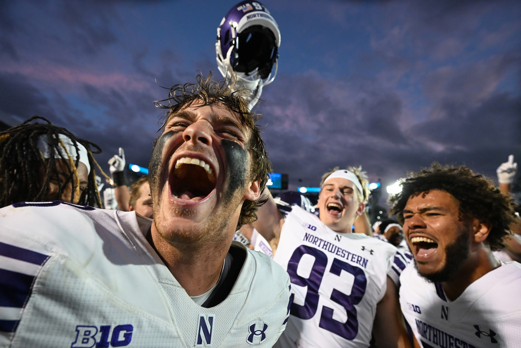 Northwestern quarterback Preston Stone (8) and defensive lineman Caden O'Rourke (93) celebrate their win over Penn State during an NCAA college football game, Saturday, Oct. 11, 2025, in State College, Pa. (AP Photo/Barry Reeger)
