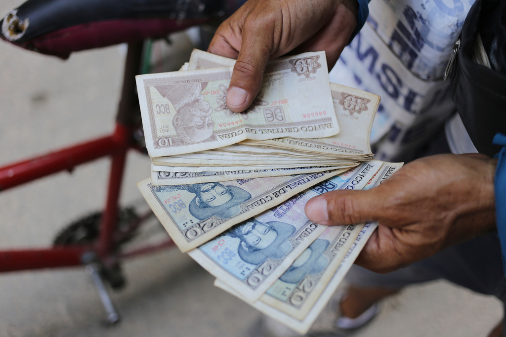 FILE - An ice cream street vendor shows his Cuban pesos in Havana, Cuba, April 20, 2024. (AP Photo/Ariel Ley, File)