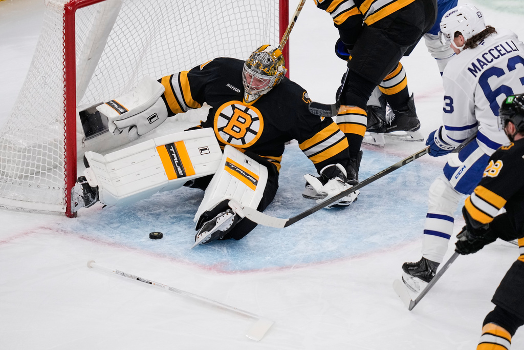 Boston Bruins goaltender Jeremy Swayman (1) drops to the ice to make a save, after losing his stick, on a shot by Toronto Maple Leafs left wing Matias MacCelli (63) during the first period of an NHL hockey game, Tuesday, March 24, 2026, in Boston. (AP Photo/Charles Krupa)