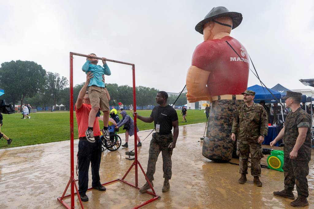 A child attempts to do pull-ups at the U.S. Marine Corps exhibit at the Great American State Fair on the National Mall, Sunday June 28, 2026, in Washington. (AP Photo/Jen Golbeck)