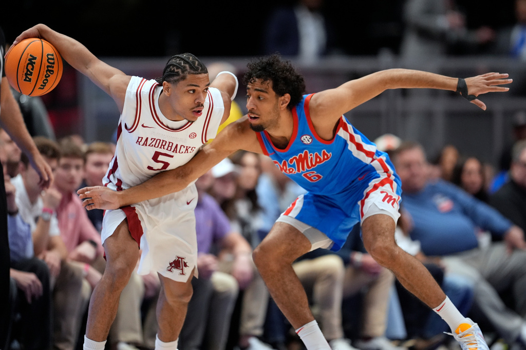 Arkansas guard Darius Acuff Jr. (5) dribbles the ball past Mississippi guard Ilias Kamardine (6) during the first half of an NCAA college basketball game in the semifinals of the Southeastern Conference tournament Saturday, March 14, 2026, in Nashville, Tenn. (AP Photo/George Walker IV)