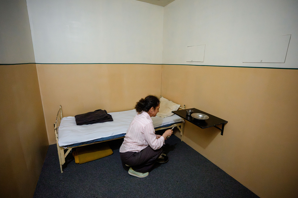 Oana Demetriade, historian at the National Council for Studying the Securitate Archives (CNSAS), puts the final touches in a replica of a Securitate prison cell, a day before the opening of the "A.REST 1989 — The Securitate Video Archive" exhibition, at the National History Museum of Romania, in Bucharest, Romania, Monday, June 15, 2026. (AP Photo/Andreea Alexandru)