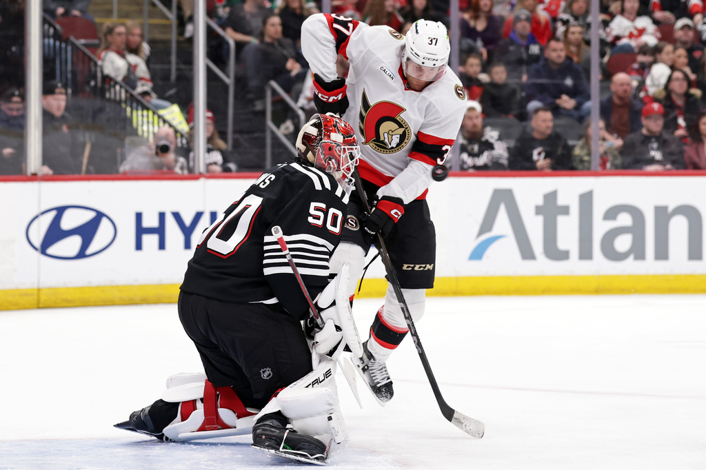 New Jersey Devils goaltender Nico Daws defends against Ottawa Senators left wing Warren Foegele (37) during the first period of an NHL hockey game Sunday, April 12, 2026, in Newark, N.J. (AP Photo/Adam Hunger)