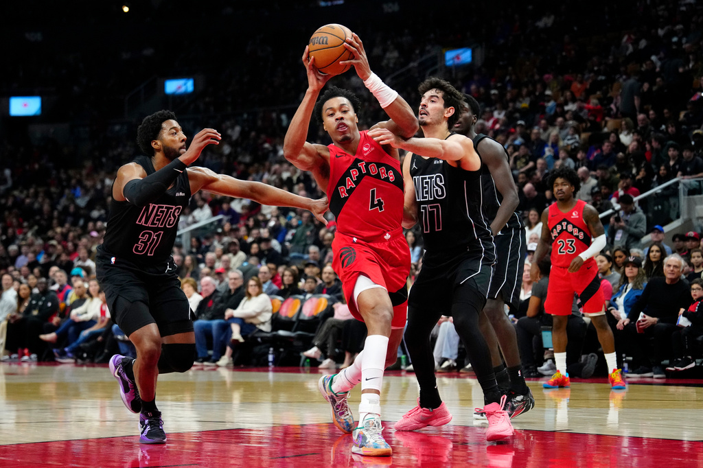 Toronto Raptors forward Scottie Barnes (4) drives past Brooklyn Nets forward Chaney Johnson (31) and teammate Michael Porter Jr. (17) during first half NBA basketball action in Toronto, Sunday, April 12, 2026. (Frank Gunn/The Canadian Press via AP)