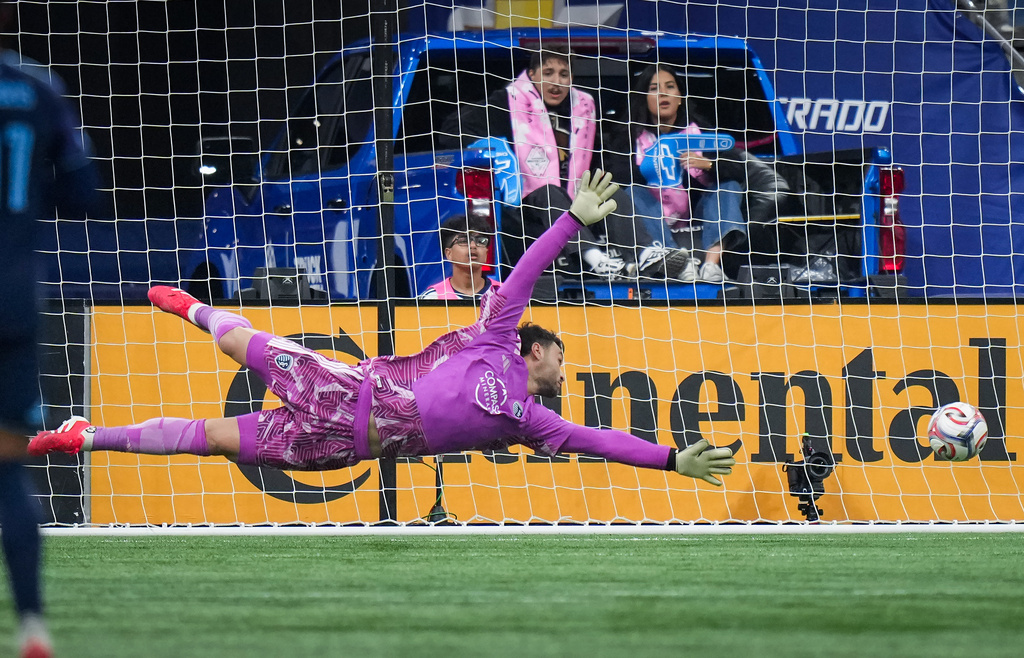 Sporting Kansas City goalkeeper John Pulskamp allows a goal to Vancouver Whitecaps' Bruno Caicedo, not seen, during the first half of an MLS soccer match, in Vancouver, on Friday, April 17, 2026. (Darryl Dyck/The Canadian Press via AP)