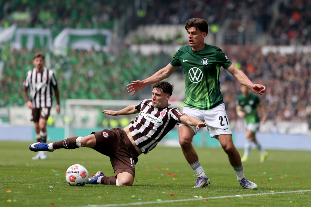 St. Pauli's Arkadiusz Pyrka, left, and Wolfsburg's Joakim Maehle fight for the ball during the German Bundesliga soccer match between FC St. Pauli and VfL Wolfsburg in Hamburg, Germany, Saturday, May 16, 2026. (Christian Charisius/dpa via AP)