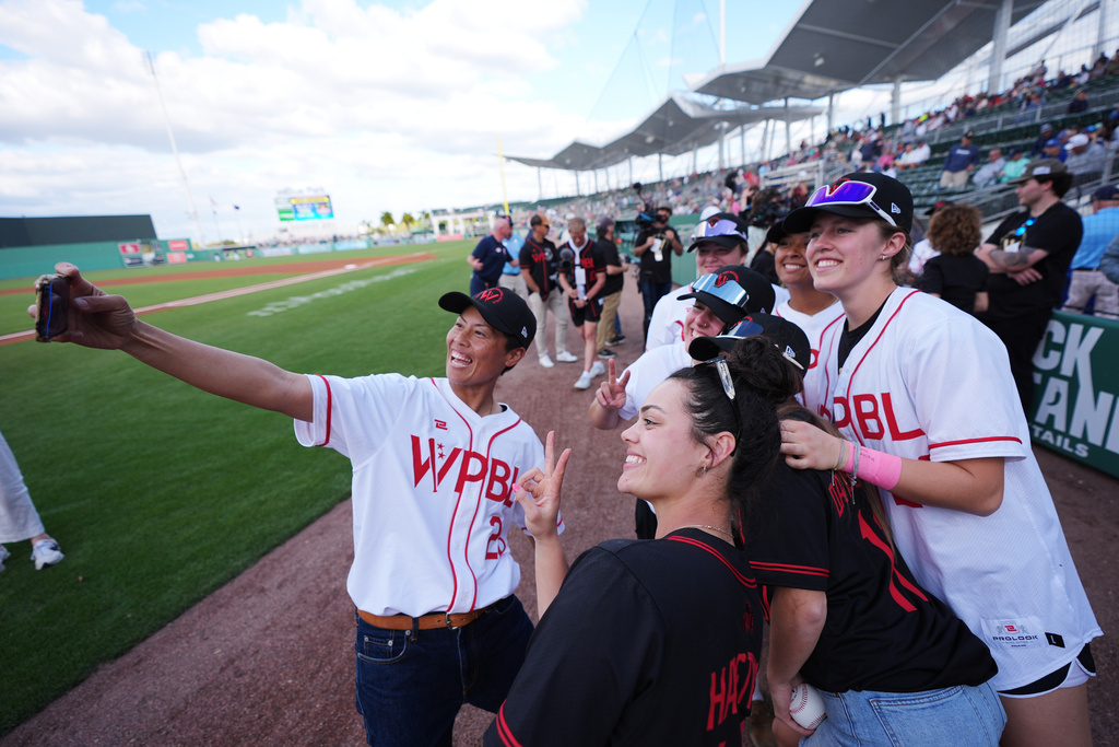 Women's Pro Baseball League players including Ayami Sato, left, take a photo on the field ahead of a spring training game between the Boston Red Sox and the Minnesota Twins, Thursday, March 19, 2026, in Fort Myers, Fla. (AP Photo/Rebecca Blackwell)