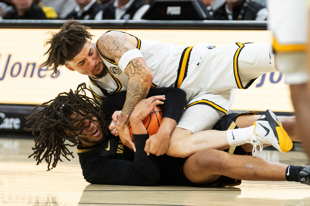 Vanderbilt's Devin McGlockton, bottom, and Missouri's Jayden Stone, top, battle for a loose ball during the first half of an NCAA college basketball game Wednesday, Feb. 18, 2026, in Columbia, Mo. (AP Photo/L.G. Patterson)