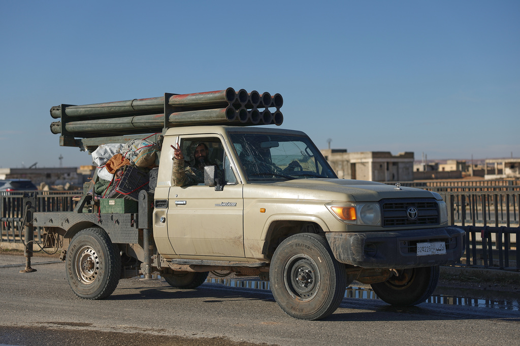 Syrian government soldiers drive a vehicle with rocket launcher, on a highway to Deir Hafer village amid the possibility of escalating fighting with the Kurdish fighters, in eastern Aleppo, Syria, Wednesday, Jan. 14, 2026. (AP Photo/Ghaith Alsayed)