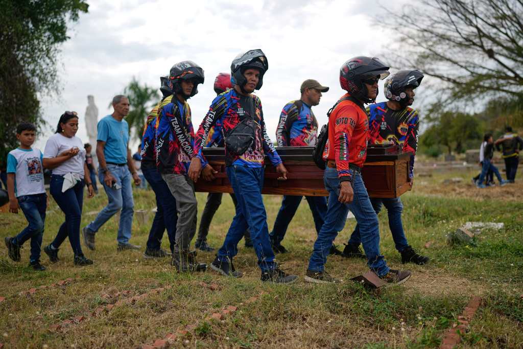 Members of a motorcycle club, friends of Edilson Torres, a Venezuelan police officer who died in prison a month after being arrested on accusations of treason, carry his coffin at a cemetery in Guanare, Venezuela, Tuesday, Jan. 13, 2026. (AP Photo/Ariana Cubillos)