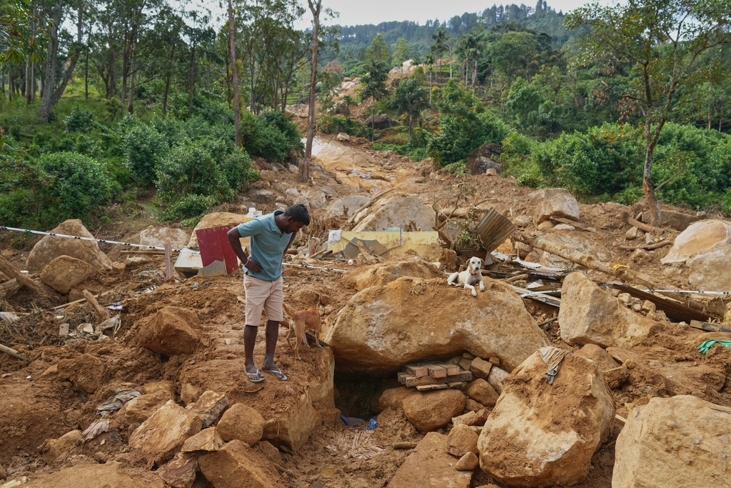 Marasamy Suresh, a tea plantation worker, looks at where the body of a boy is buried in the rubble of a plantation workers' living quarters after Cyclone Ditwah led to floods and landslides at Craighead Estate in Nawalapitiya, Sri Lanka, Friday, Dec. 12, 2025. (AP Photo/Eranga Jayawardena)