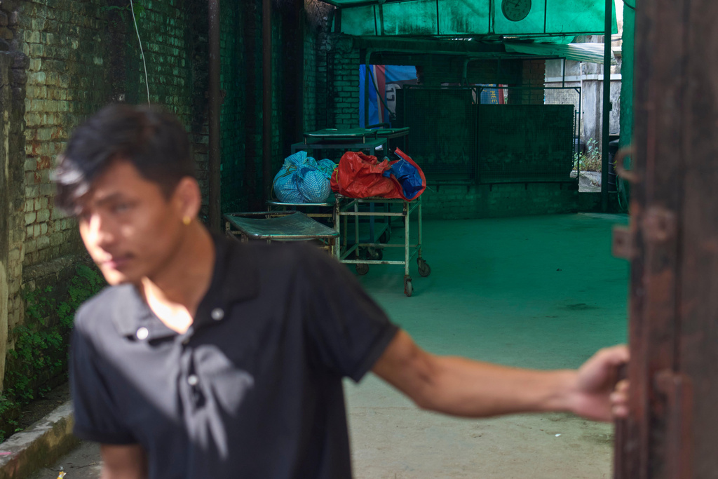 Hospital staff closes the gate after unloading the body of a climber killed in an avalanche on Mount Yalung Ri at Tribhuvan University Teaching Hospital in Kathmandu, Nepal, Wednesday, Nov. 5, 2025. (AP Photo/Niranjan Shrestha)