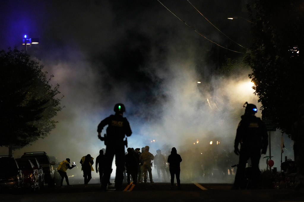 FILE - Law enforcement officers stand after deploying tear gas outside a U.S. Immigration and Customs Enforcement facility during a protest on Oct. 4, 2025, in Portland, Ore. (AP Photo/Jenny Kane, File)
