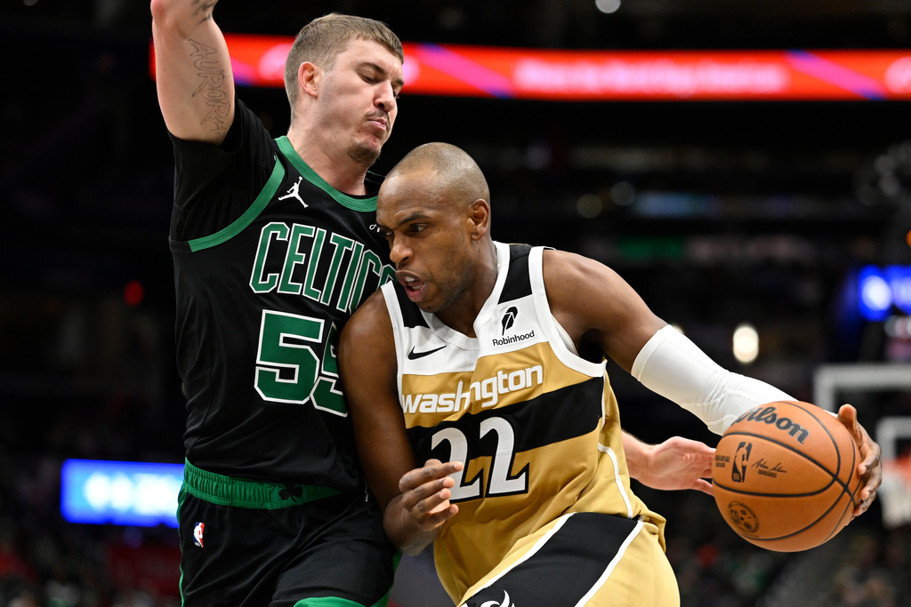 Washington Wizards forward Khris Middleton (22) drives to the basket against Boston Celtics guard Baylor Scheierman during the first half of an NBA basketball game Thursday, Dec. 4, 2025, in Washington. (AP Photo/John McDonnell)