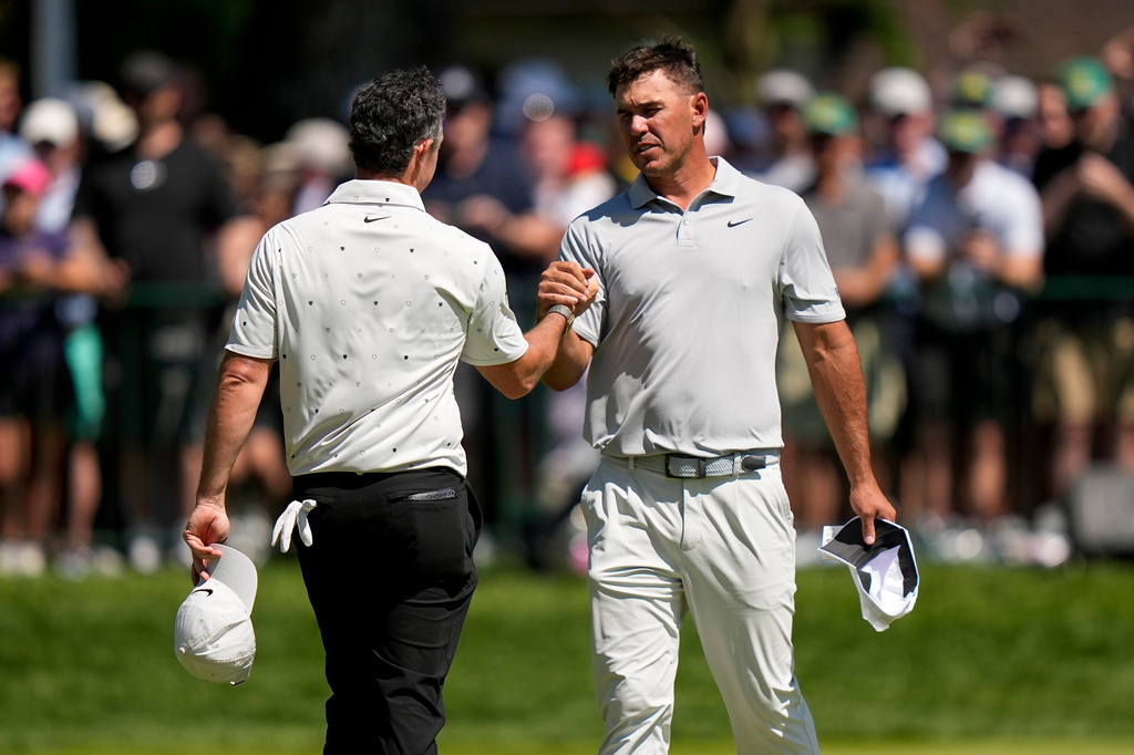 Rory McIlroy, of Northern Ireland, left, greets Brooks Koepka after they finished their round during the third round of the PGA Championship golf tournament at Aronimink Golf Club, Saturday, May 16, 2026, in Newtown Square, PA. (AP Photo/Frank Franklin II)