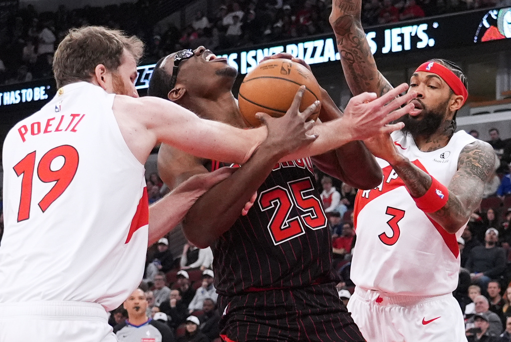Chicago Bulls center Jalen Smith, center, battles for a ball against Toronto Raptors center Jakob Poeltl, left, and forward Brandon Ingram during the first half of an NBA basketball game in Chicago, Wednesday, March 18, 2026. (AP Photo/Nam Y. Huh)
