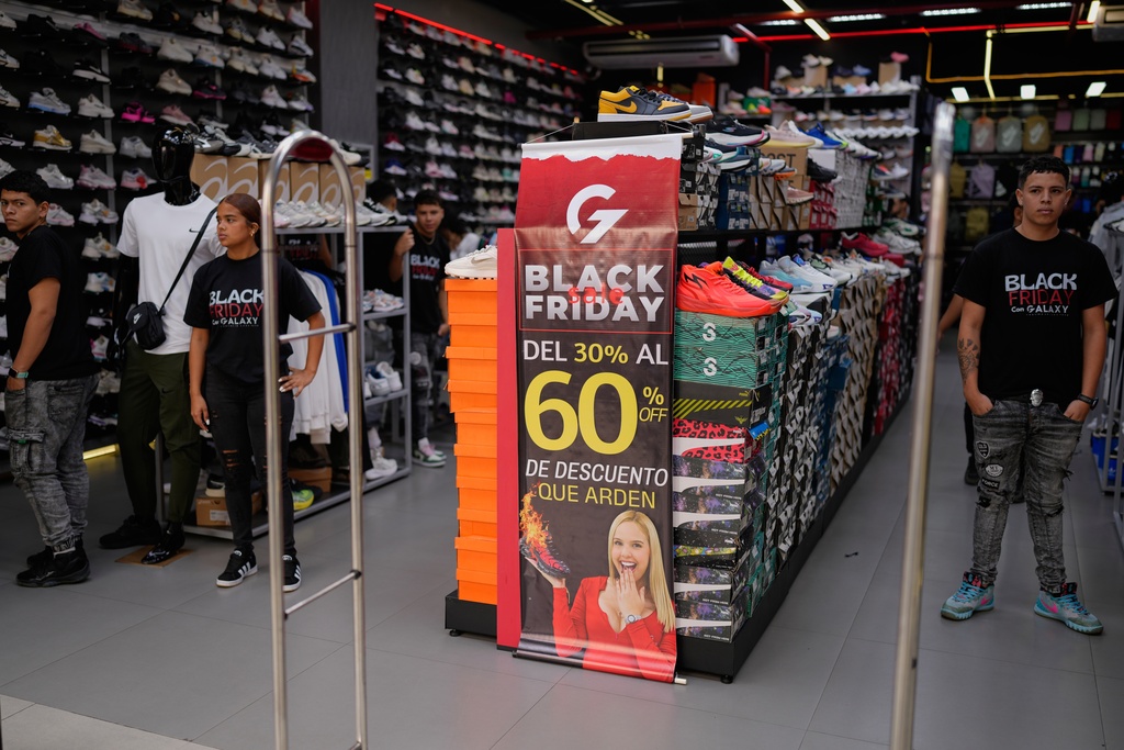 Employees wait for customers at a shoe store promoting Black Friday discounts in Caracas, Venezuela, Friday, Nov. 28, 2025. (AP Photo/Ariana Cubillos)