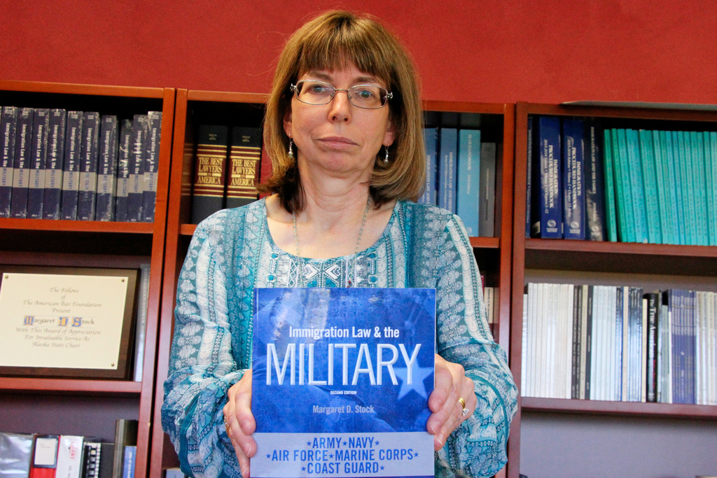 FILE - Margaret Stock, an immigration lawyer, poses with a copy of her book, "Immigration Law and the Military" at her office in Anchorage, Alaska, July 3, 2018. (AP Photo/Mark Thiessen)