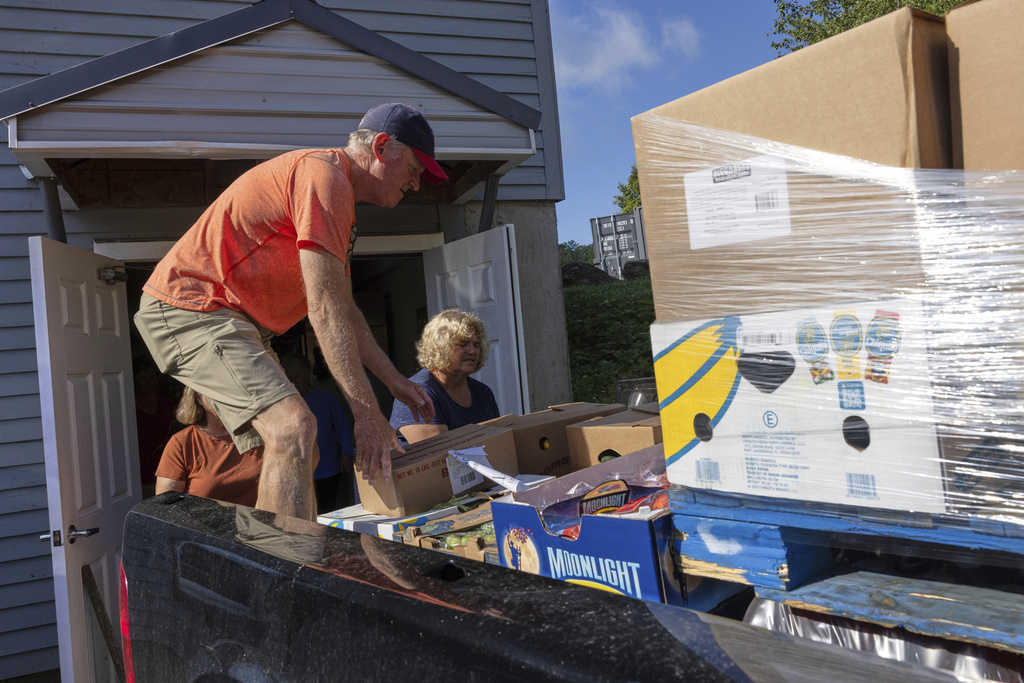 Neighbors Cupboard volunteers Mike Masnyk and Ellie Jordan unload the morning delivery of produce in Winterport, Maine, on Tuesday, Aug. 26, 2025. (Katherine Emery/The Maine Monitor via AP)
