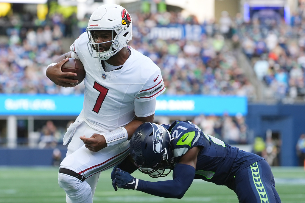 Arizona Cardinals quarterback Jacoby Brissett (7) gets tackled by Seattle Seahawks cornerback Devon Witherspoon (21) during the first half of an NFL football game Sunday, Nov. 9, 2025, in Seattle. (AP Photo/Lindsey Wasson)
