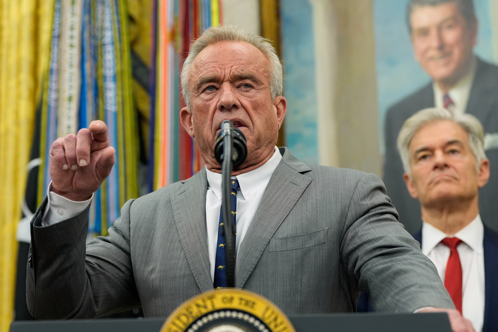 Health and Human Services Secretary Robert F. Kennedy Jr. speaks as Centers for Medicare & Medicaid Services administrator Dr. Mehmet Oz listens during an event with President Donald Trump in the Oval Office of the White House, Friday, Oct. 10, 2025, in Washington. (AP Photo/Alex Brandon)