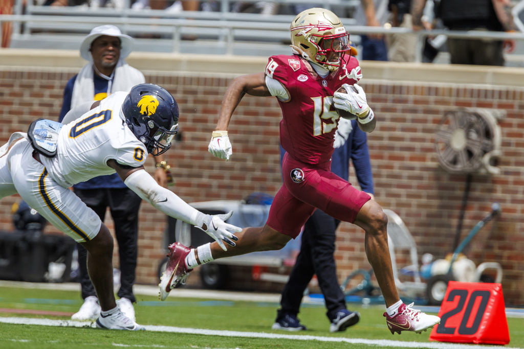 Florida State wide receiver Micahi Danzy (19) eludes East Texas A&M linebacker Tramar Gilbert (0) as he rushes 53-yards for a touchdown during the first half of an NCAA college football game, Saturday, Sept. 6, 2025, in Tallahassee, Fla. (AP Photo/Colin Hackley)