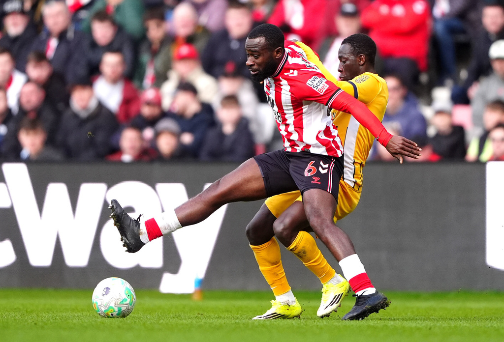 Sunderland's Lutsharel Geertruida, left, and Brighton and Hove Albion's Yankuba Minteh fight for the ball during the Premier League match in Sunderland, England, Saturday March 14, 2026. (Owen Humphreys/PA via AP)