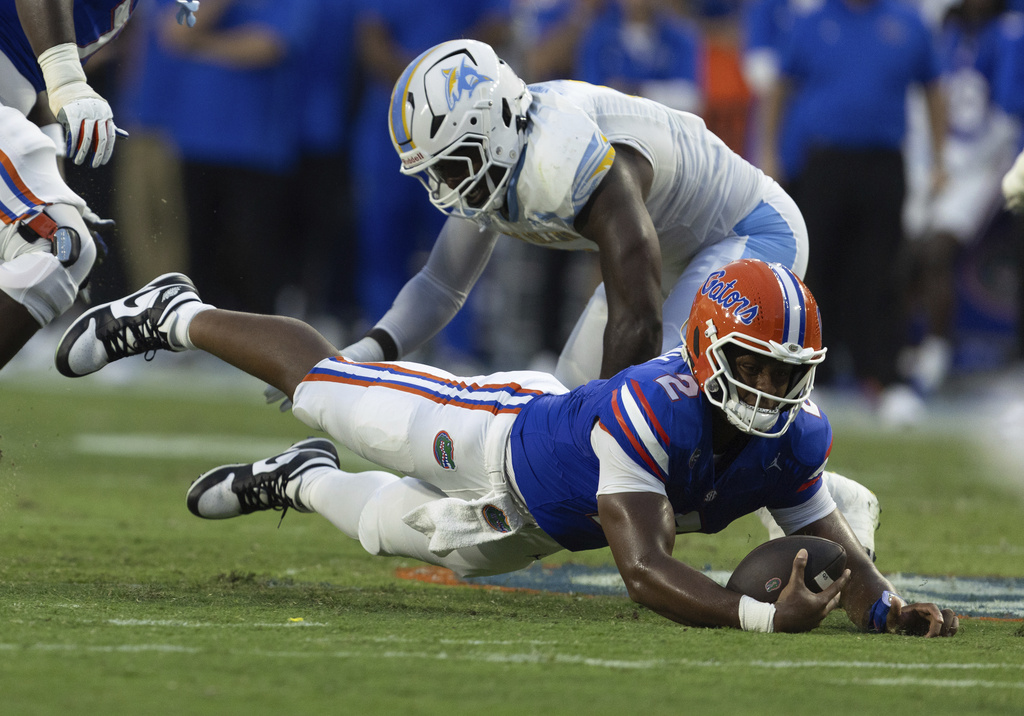 Florida quarterback DJ Lagway (2) dives against LIU Brooklyn defensive end Ja'Nyus Morgan, right, during the first half of an NCAA college football game Saturday, Aug. 30, 2025, in Gainesville, Fla. (AP Photo/Alan Youngblood)