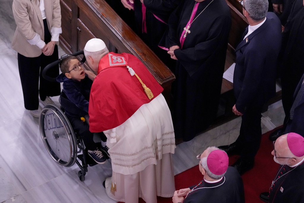 Pope Leo XIV greets a child as he meets the clergy at the Cathedral of the Holy Spirit, in Istanbul, Turkey, Friday, Nov. 28, 2025. (AP Photo/Domenico Stinellis)