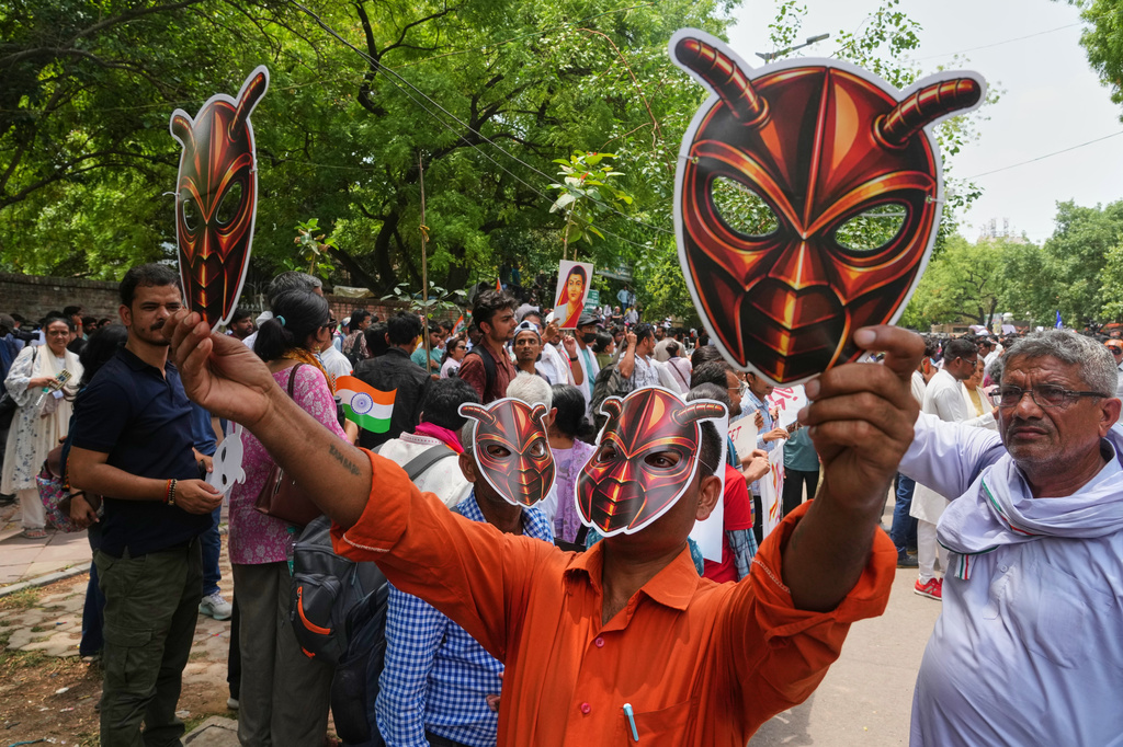 Supporters of the Cockroach Janta Party wear and display masks during a protest demonstration in New Delhi, India, Saturday, June 6, 2026. (AP Photo/Manish Swarup)