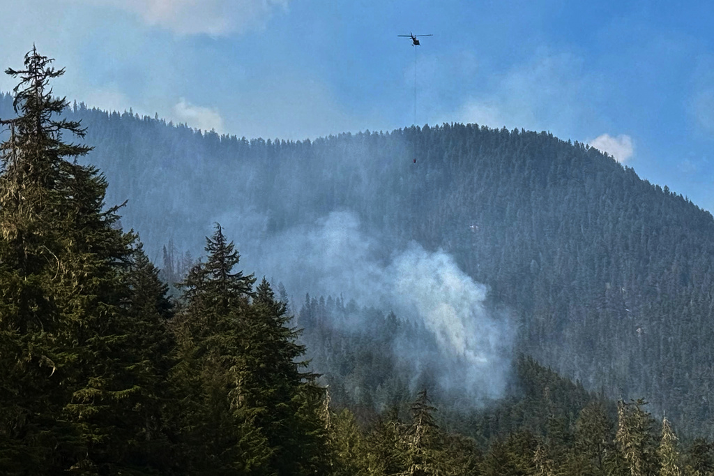 Fire crews drop water on a wildfire along Highway 3 in Manning Park, British Columbia, as fires burn throughout the southeastern part of the province on Wednesday, Aug. 12, 2026. (AP Photo/Haven Daley)