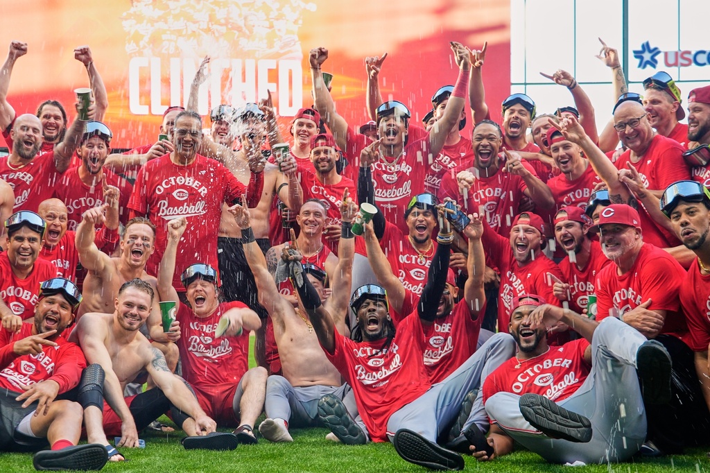 The Cincinnati Reds celebrate as they take a team photo after making it into the playoffs after a baseball game against the Milwaukee Brewers Sunday, Sept. 28, 2025, in Milwaukee. (AP Photo/Morry Gash)