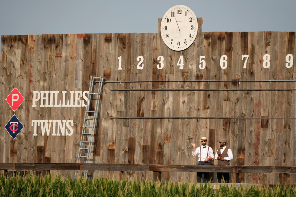 Scoreboard workers look on before a baseball game between the Minnesota Twins and the Philadelphia Phillies at the Field of Dreams movie site, Thursday, Aug. 13, 2026, in Dyersville, Iowa. (AP Photo/Charlie Neibergall)