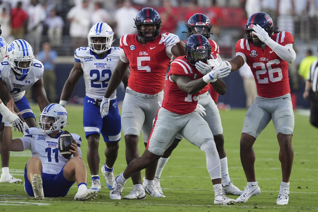 Mississippi defenders celebrate the sacking of Georgia State quarterback Christian Veilleux (11), left, during the first half of an NCAA college football game in Oxford, Miss., Saturday, Aug. 30, 2025. (AP Photo/Rogelio V. Solis)