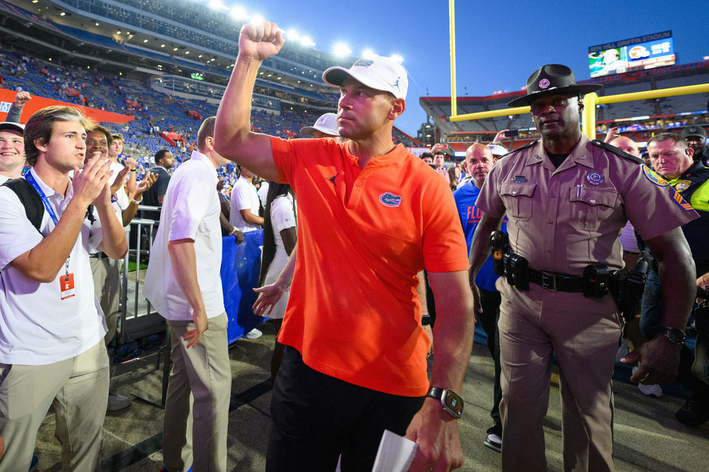 Florida head coach Jon Sumrall, center, pumps his fist after after his team won an NCAA college football game against Mississippi, Saturday, Sept. 26, 2026, in Gainesville, Fla. (AP Photo/Noah Lantor)