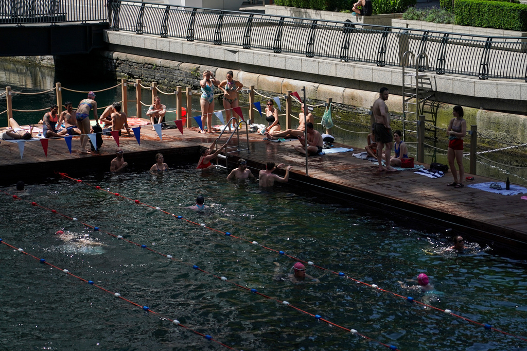 People swim in an outdoor swimming pool in London, Tuesday, June 23, 2026 as a heat wave is predicted across Britain.(AP Photo/Alberto Pezzali)