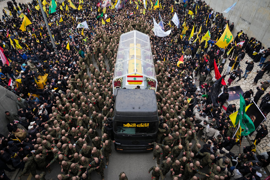 FILE - A trailer carrying the coffins containing the bodies of Hezbollah's former leader Hassan Nasrallah and his cousin and successor Hashem Safieddine drives through the crowd as it enters the Sports City Stadium during a funeral procession in Beirut, Feb. 23, 2025. (AP Photo/Hassan Ammar, File)
