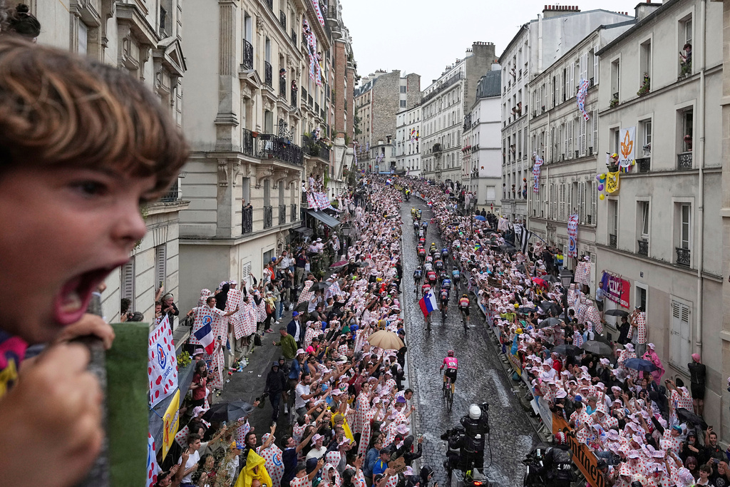 A boy shouts as the pack rides up the Montmartre hill during the last stage of the Tour de France cycling race between Mantes-la-Ville and Paris, July 27, 2025 in Paris (AP Photo/Laurent Cipriani, File)