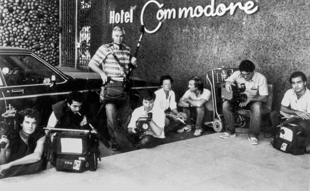 FILE - Television crews, some wearing flak jackets, crouch down in front of the Commodore Hotel, in West Beirut, on Aug. 31,1983, as the Lebanese Army battles with Shiite and Druse militiamen. (AP Photo/Bill Foley, File)