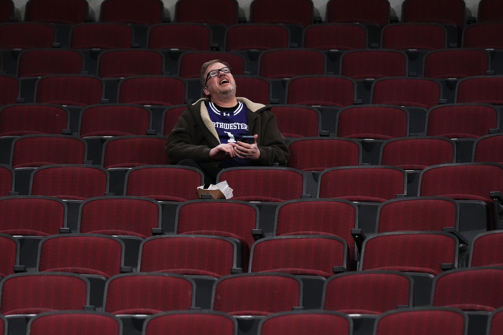 A Northwestern fan looks up the score board during the second half of an NCAA college basketball game between Oklahoma State and Northwestern in the CBS Sports Thanksgiving Classic tournament Thursday, Nov. 27, 2025, in Chicago. (AP Photo/Nam Y. Huh)