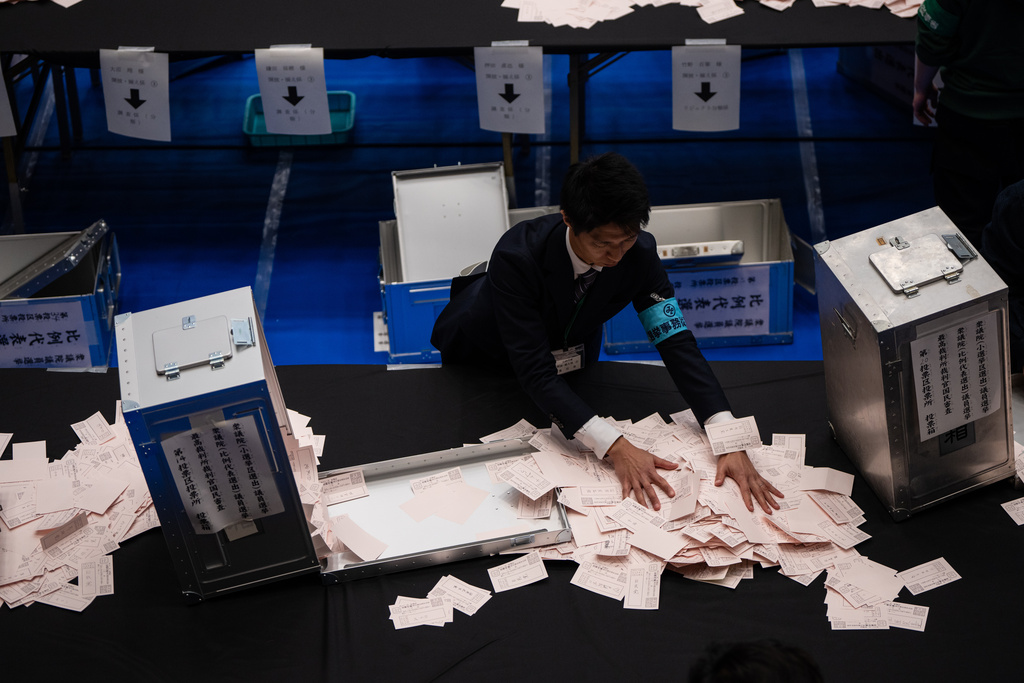 Election officials open ballot boxes as they prepare to count the votes in the lower house election in Tokyo, Sunday, Feb. 8, 2026. (AP Photo/Louise Delmotte)