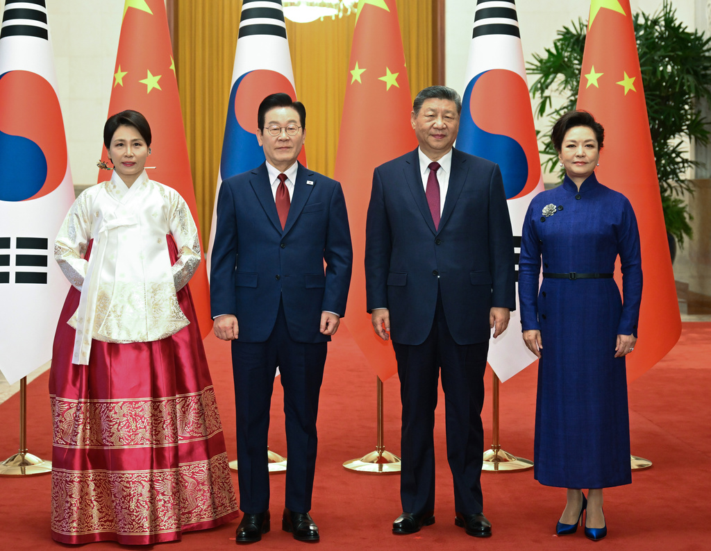 In this photo released by Xinhua News Agency, visiting South Korean President Lee Jae Myung, center left, and his wife Kim Hea Kyung, left, stand with Chinese President Xi Jinping, center right, and his wife Peng Liyuan, right, as they pose for a photo shoot at the Great Hall of the People, in Beijing, Monday, Jan. 5, 2026. (Xie Huanchi/Xinhua via AP)