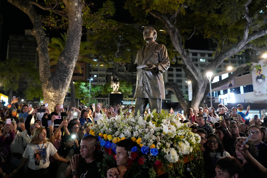 Believers carry a statue of Jose Gregorio Hernandez during an event to celebrate Venezuela's first saint, Hernandez, as he will be canonized by Pope Leo XIV, at a square in Caracas, Venezuela, Sunday, Oct. 19, 2025. (AP Photo/Ariana Cubillos)