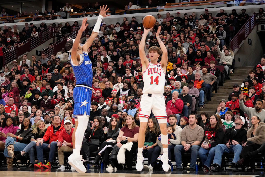 Chicago Bulls forward Matas Buzelis, right, shoots a 3-point basket over Orlando Magic guard Anthony Black during the second half of an NBA basketball game Friday, Jan. 2, 2026, in Chicago. (AP Photo/David Banks)